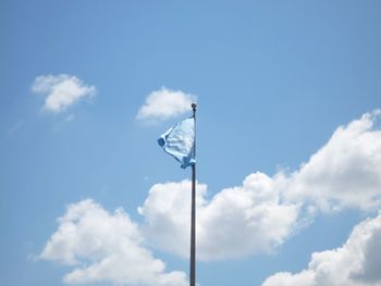 Low angle view of flag waving against sky