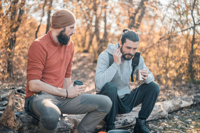 Man sitting in forest during autumn