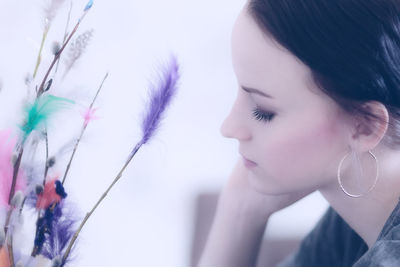 Side view of young woman by decoration at home