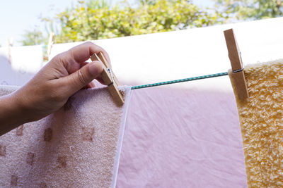 Close-up of cropped hand applying clothespin on towel