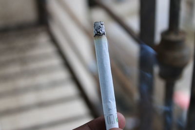 Close-up of hand holding cigarette