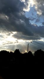 Silhouette of trees against cloudy sky