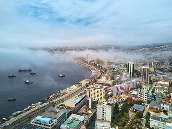 High angle view of buildings by sea against sky