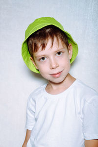 Portrait of a boy in a green panama hat, on a white background