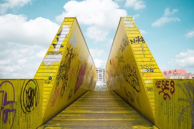 Low angle view of yellow golden gate against sky