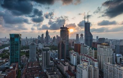 Skyscrapers in city against cloudy sky