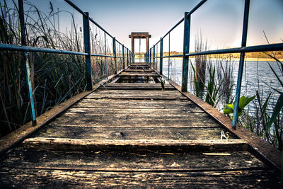 Surface level of footbridge on footpath against sky