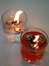 Close-up of tea light candles on glass table