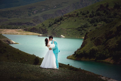 Love, wedding and married couple kissing by the lake outdoors in honor of their romantic marriage
