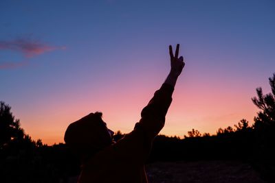 Silhouette man standing by tree against sky during sunset