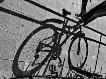 Shadow of bicycle on road against wall