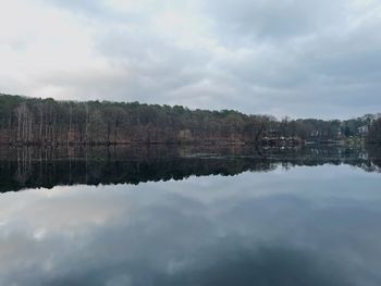 Scenic view of lake by trees against sky