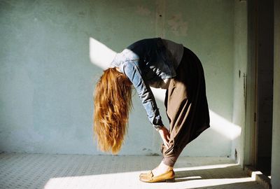 Side view of a woman bending with long blonde hair