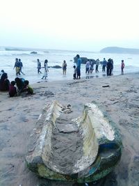 People at beach against sky