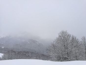 Snow covered landscape against clear sky