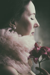 Side view of young woman blowing flowers