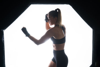 Side view of woman standing against sky at night