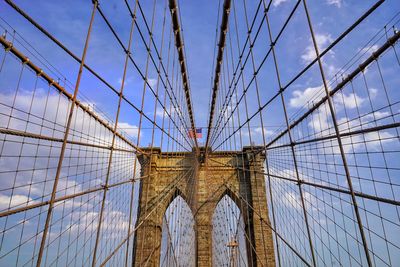 Low angle view of brooklyn bridge against cloudy sky