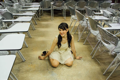 High angle view of young woman sitting on chair