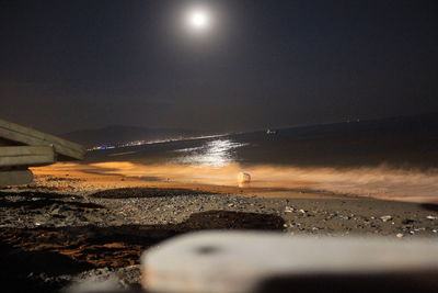 Scenic view of beach against sky at night