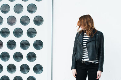 Rear view of woman standing against wall