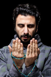 Close-up portrait of young man against black background