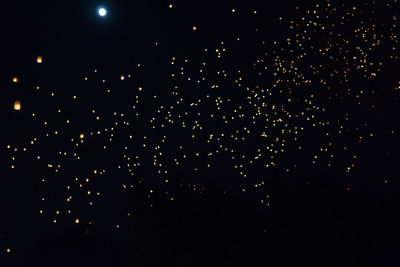 Low angle view of fireworks against sky at night