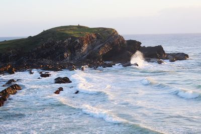 Rocks in sea against sky