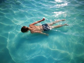 Boy floating on shallow water