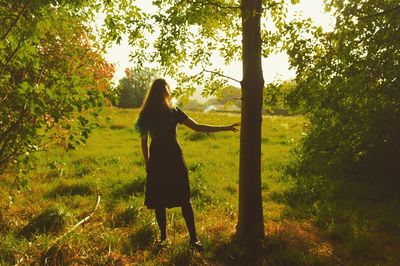 Young woman standing on tree