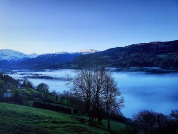 Scenic view of lake and mountains against clear sky