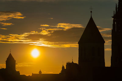 Silhouette of buildings against sky during sunset