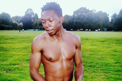 Portrait of shirtless man in park