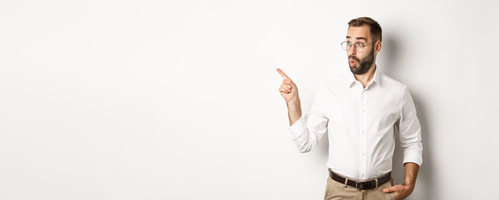 Portrait of young man standing against white background