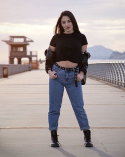 Portrait of young woman standing against wall