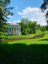 Built structure on field by trees against sky