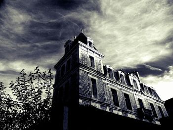 Low angle view of building against cloudy sky