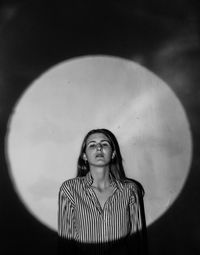 Portrait of young woman against wall