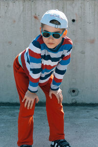 Portrait of boy standing against wall