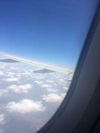 Cropped image of airplane against blue sky