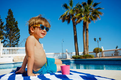 Portrait of shirtless man swimming in resort