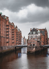 Buildings in city against cloudy sky