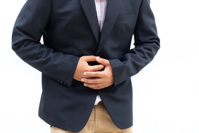 Midsection of man holding hands against white background