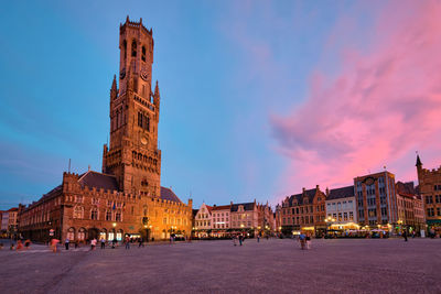 Buildings in town against sky at dusk