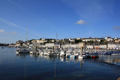 Boats moored at harbor against sky