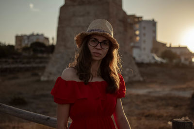 Portrait of woman standing in city against sky