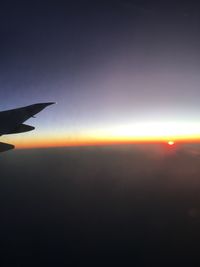 Airplane flying in sky during sunset