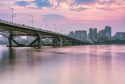 Bridge over river against buildings in city