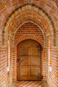 Brick corridor in an ancient castle. antique wooden door in the interior of an ancient castle.
