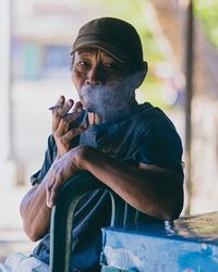 Man looking away while sitting outdoors